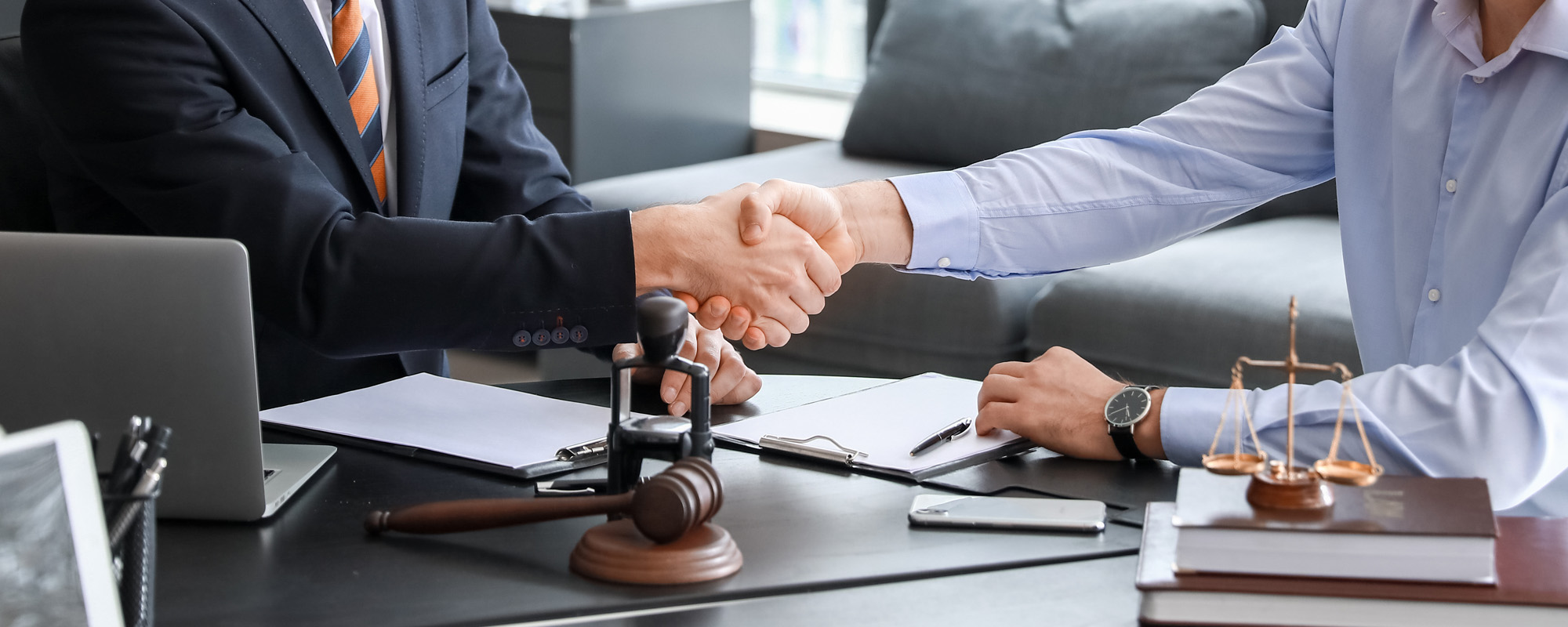 male lawyer with client shaking hands in office