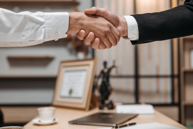 people shaking hands in lawyer office